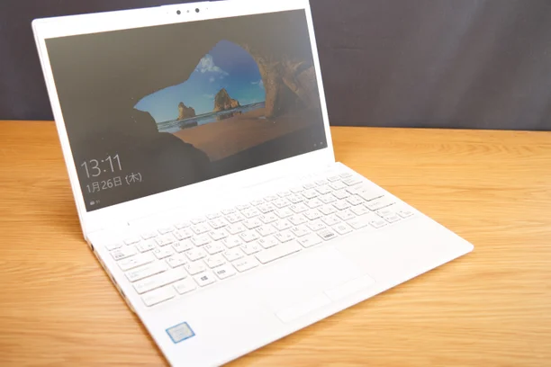 木目のデスクに置いた白いWindowsノートパソコン