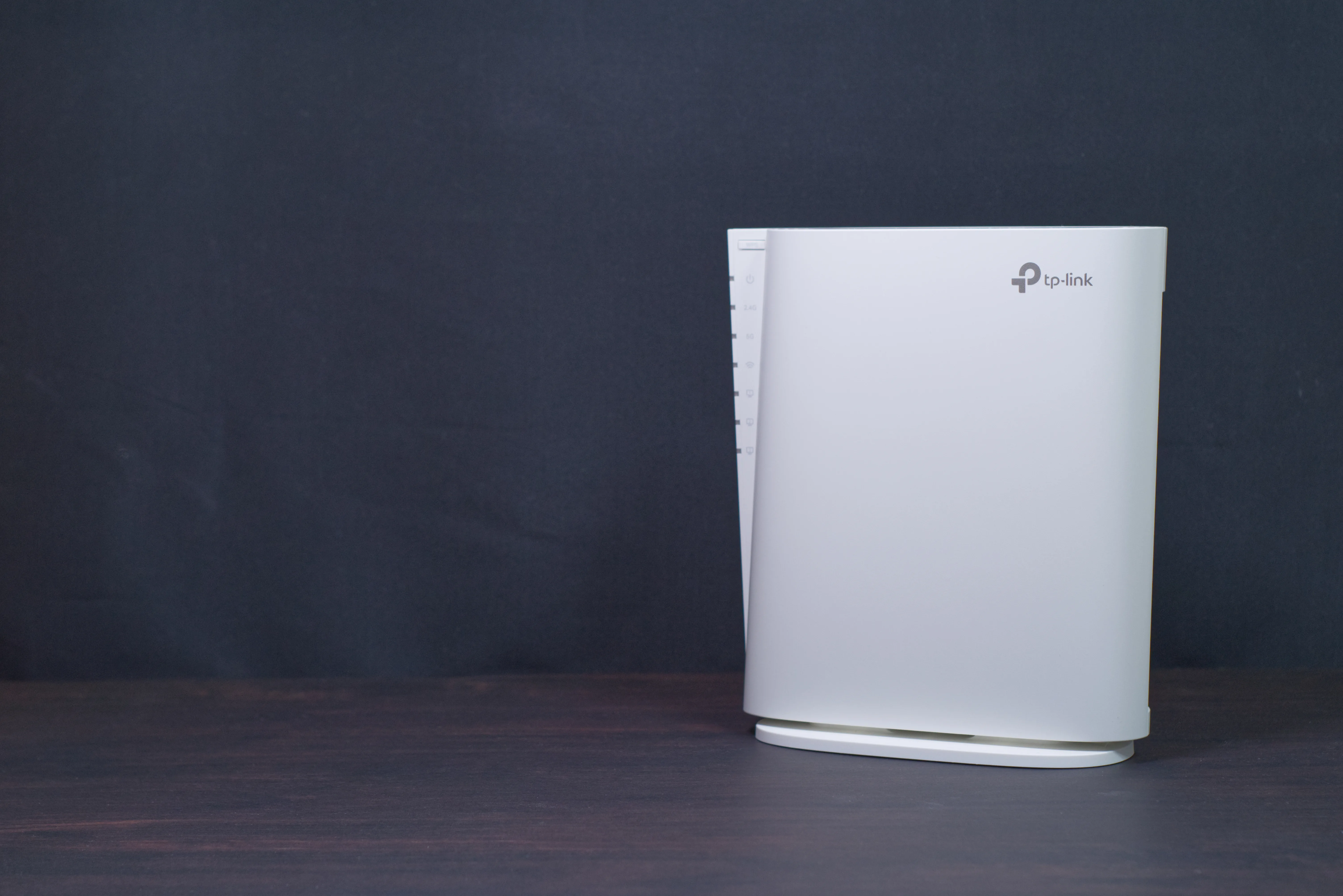 黒い背景の前に置いた白いTP-Link RE900XD