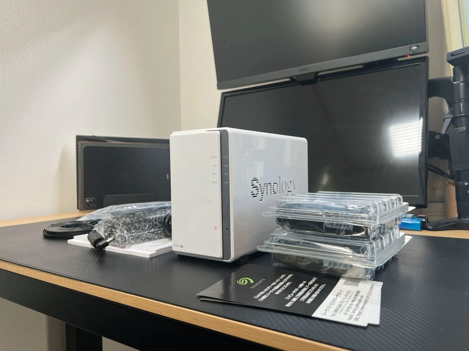 デスクに並べたSynology DS223jの本体とSeagateのHDD 2台