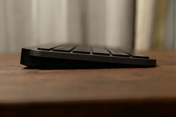 MX Keys Mini for Mac を真横から見たところ。奥が高く、手前に向かって傾いている