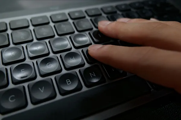 MX Keys Mini for Mac のくぼんだキートップに指を置いているところ