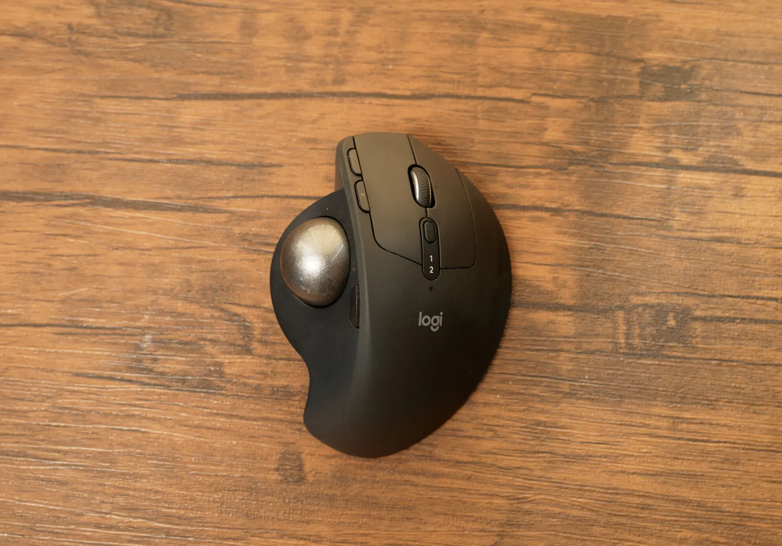 木目の机の上に置いたトラックボールマウスのロジクール MX ERGO S を真上から見たところ