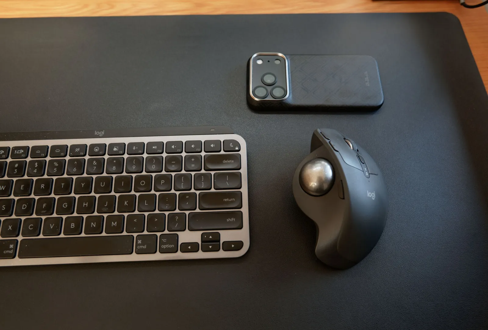 キーボードのすぐ横に置いたトラックボールマウスと、その上に置いたスマホ
