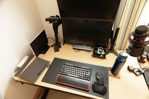上から見たデスク全体。縦置きのノートパソコン、上下2段の外部モニター、キーボードとマウス