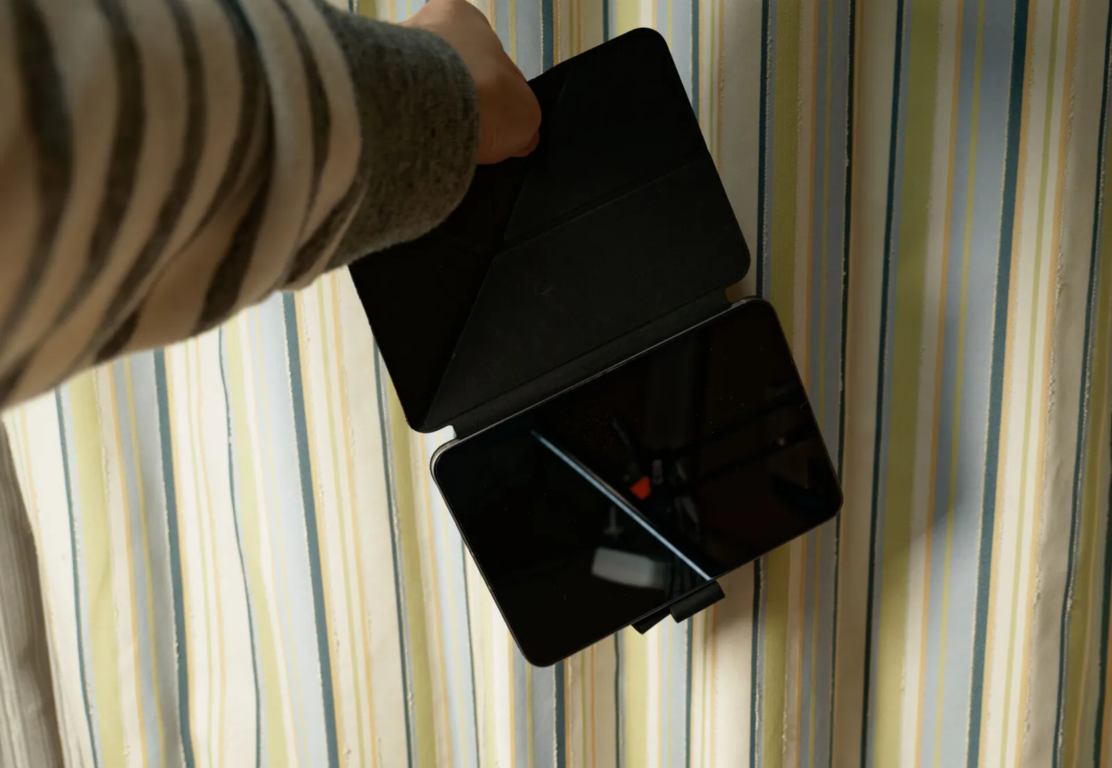 PITAKA MagEZ Folio 2のフロントカバーだけを持ってぶら下げたiPad mini 7