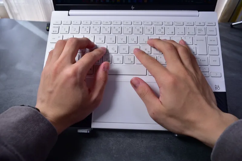 BoYata折りたたみ式スタンドにノートPCを乗せて作業している手元