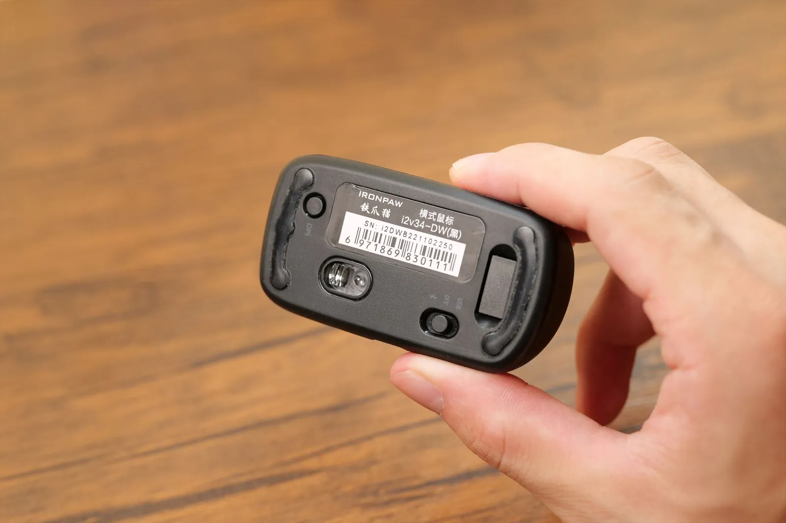 Finger Barrel Mouse i2を手に持ち裏面のスイッチを操作しているところ