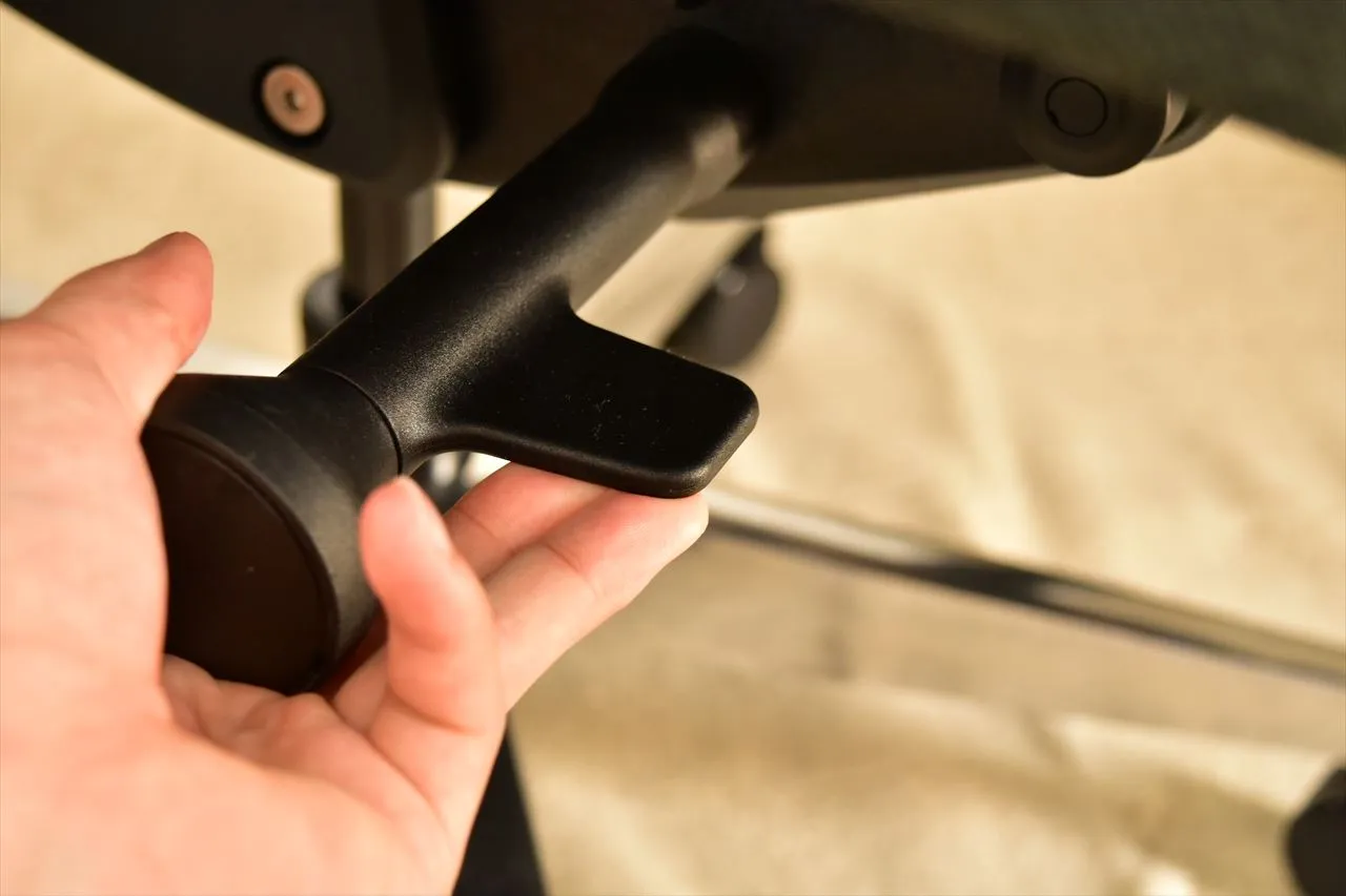 FlexiSpot C2のアームレストを手で持ち上下調整しているところ