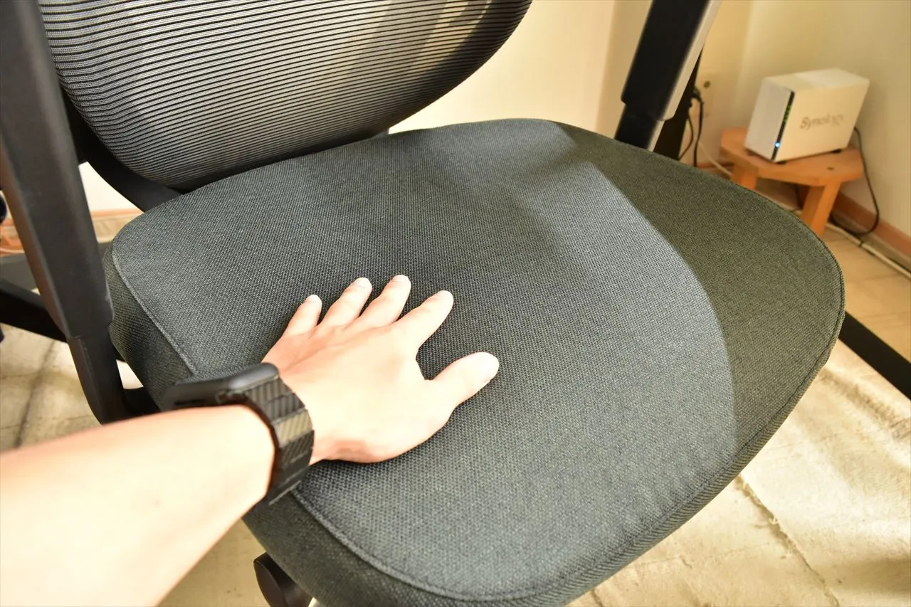 FlexiSpot C2の座面に手を置いて質感を確認しているところ
