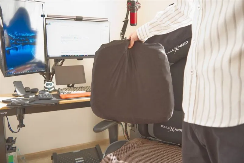 relaxheal ゲルクッションをデスク前で持ち上げている使用シーン