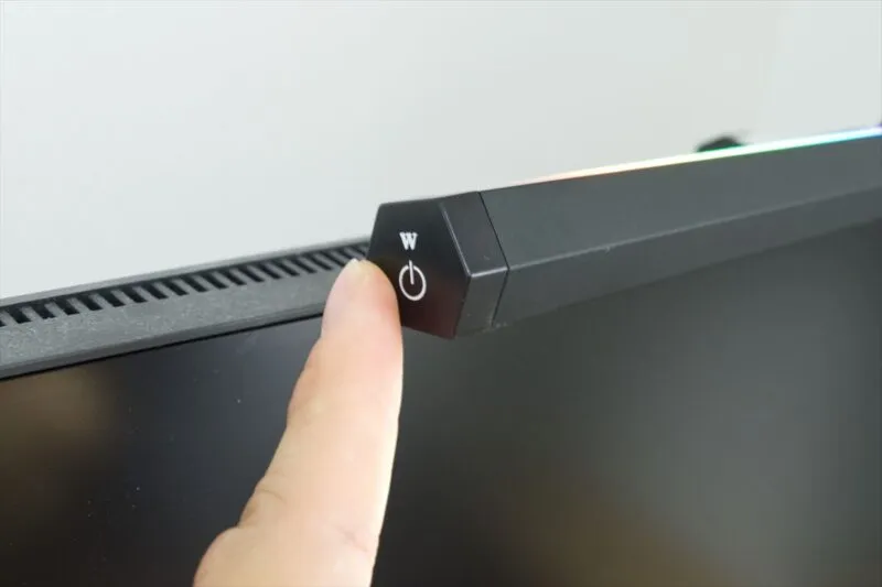 SHUWEI モニターライトの電源ボタンを指で押しているところ