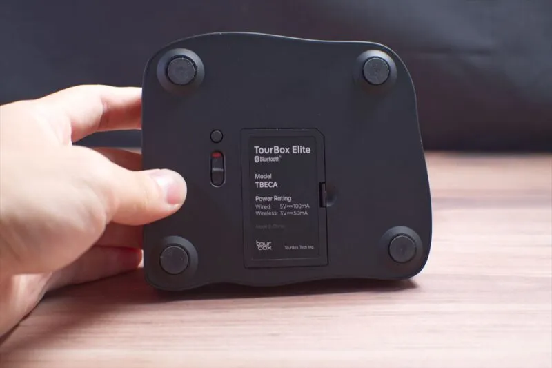 TourBox Eliteの底面にある電源スイッチを指で操作している様子